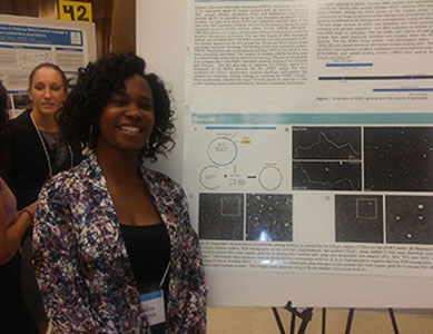 Student posing in front of a research poster